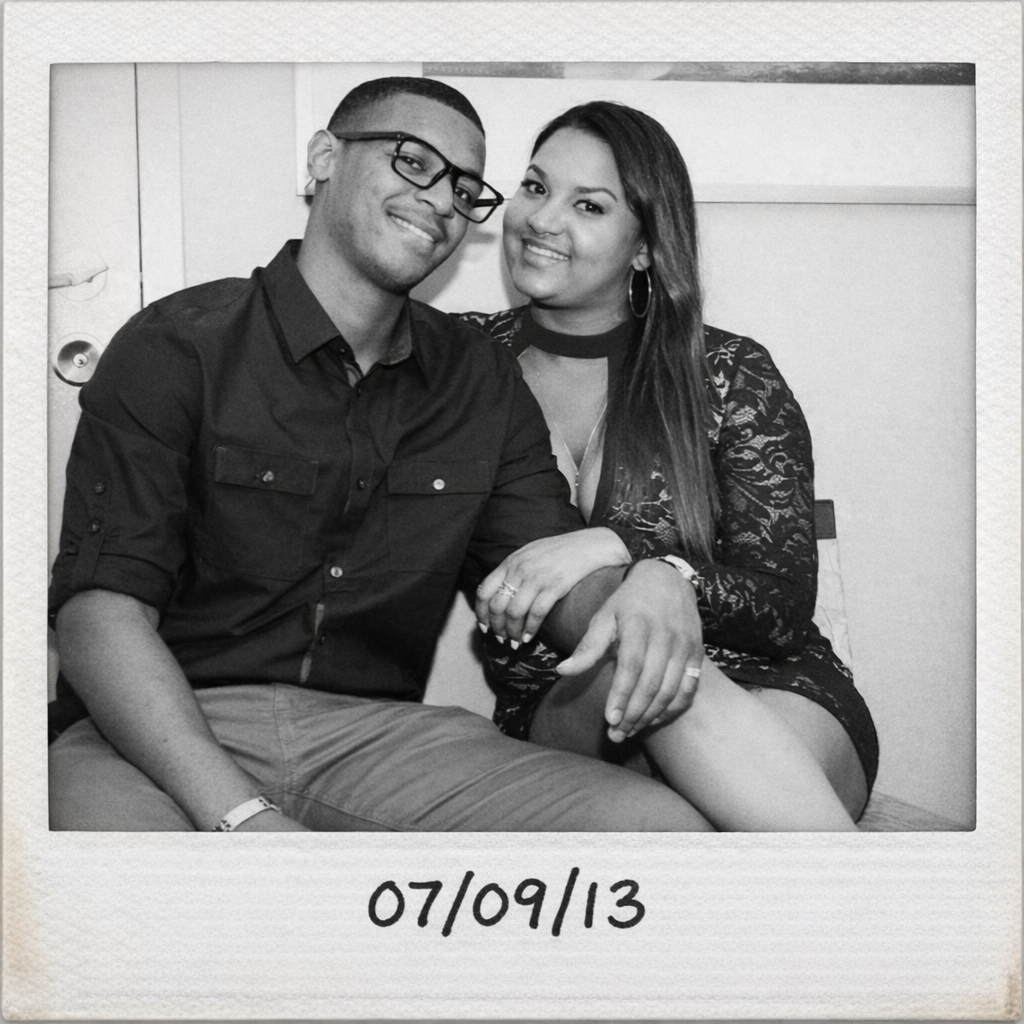 Polaroid photo of a couple posing together on a bed with the date 06/10/19 written on the polaroid.